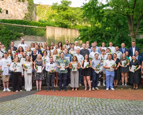 Alle Absolventinnen stehen für ein Gruppenfoto auf dem Schulhof der BBS 1 Osterode. Mit auf dem Bild sind Lehrkräfte, der Schulleiter, und Vertreter und Vertreterinnen der IHK Hannover und der Agentur für Arbeit.